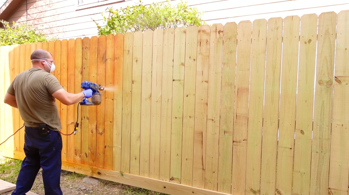 Professional fence contractor staining wood fence in La Porte, TX